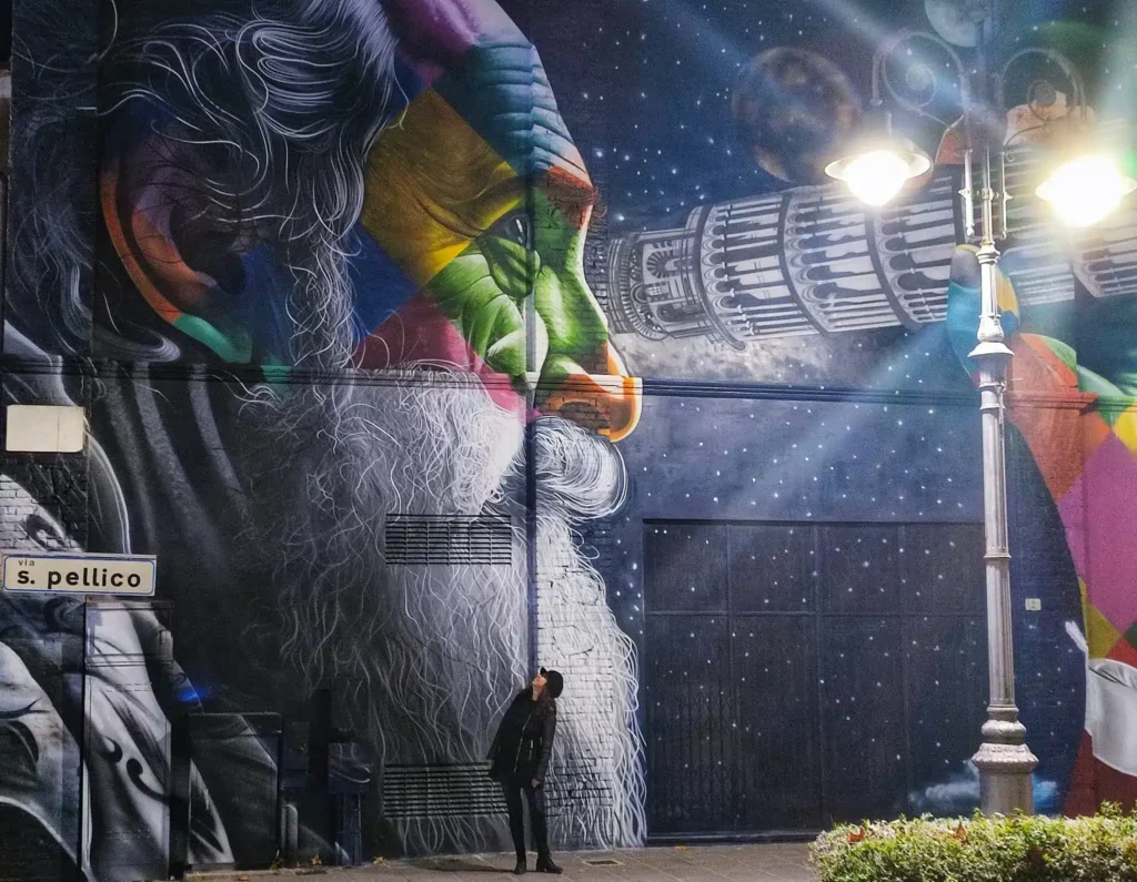 Io sotto al murales di kobra a Pisa dedicato a Galileo