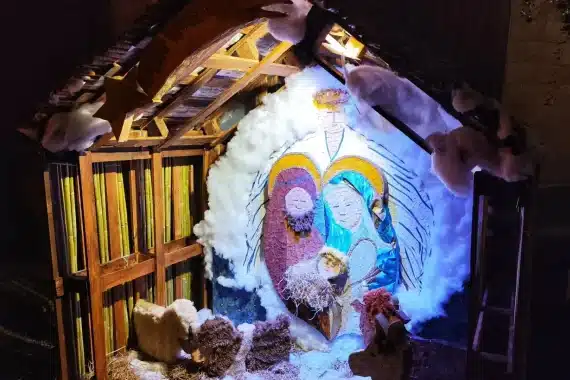 Presepe con la Sacra Famiglia in mosaico e neve di cotone in un paese della Toscana