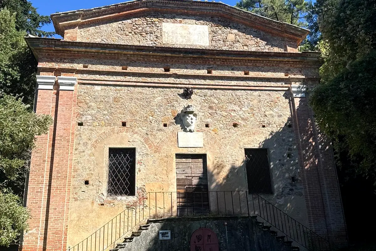 Facciata del Cisternone di Asciano con lo stemma mediceo