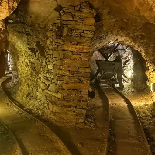 Galleria delle Miniere dell'Argento Vivo di Levigliani con binari, pilastro in pietra e manichino raffigurante un minatore