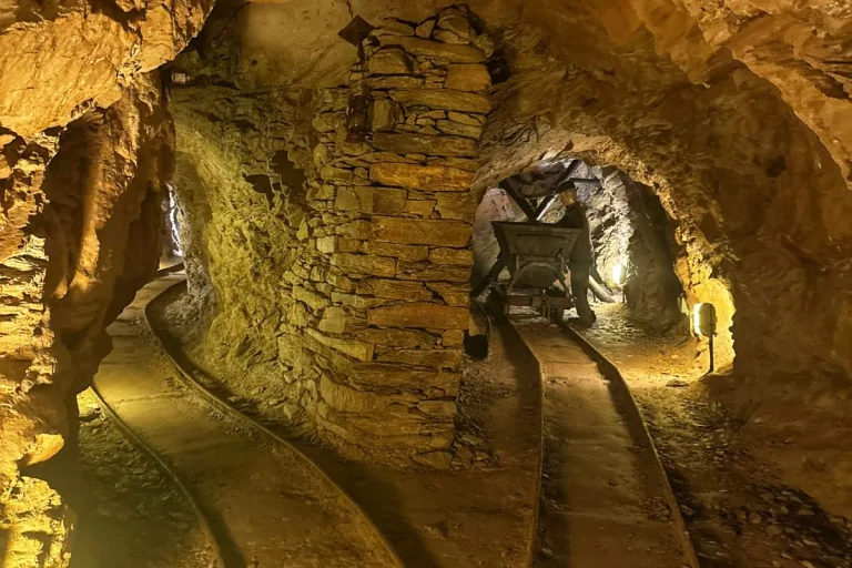 Galleria delle Miniere dell'Argento Vivo di Levigliani con binari, pilastro in pietra e manichino raffigurante un minatore