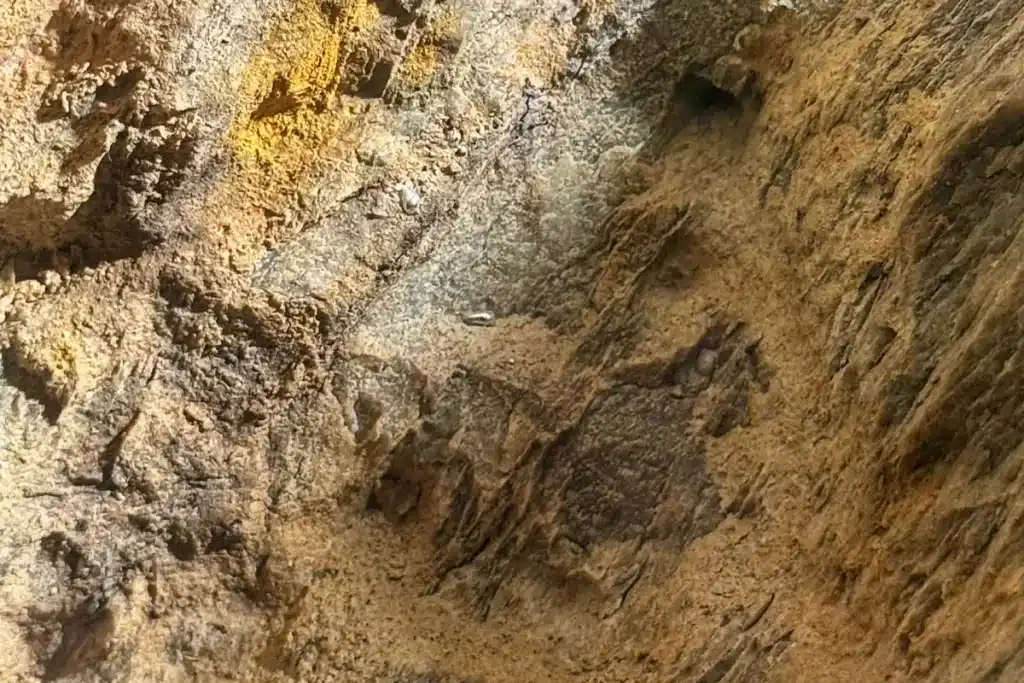 Gocce di mercurio nativo visibili sulla parete rocciosa nella cava romana delle Miniere dell'Argento Vivo di Levigliani