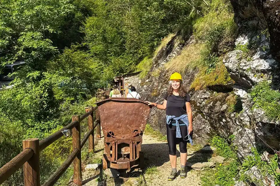 Sabrina accanto a un carrello minerario originale lungo il sentiero esterno delle miniere